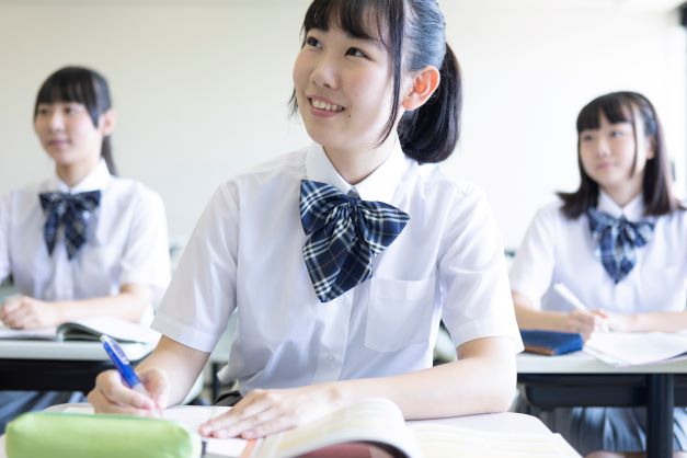 女子生徒複数名が教室で授業を受けている_small
